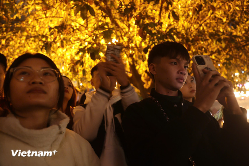 Người dân hồ hởi ghi lại những khoảnh khắc đẹp, ưng ý nhất. (Ảnh: Hoài Nam/Vietnam+)