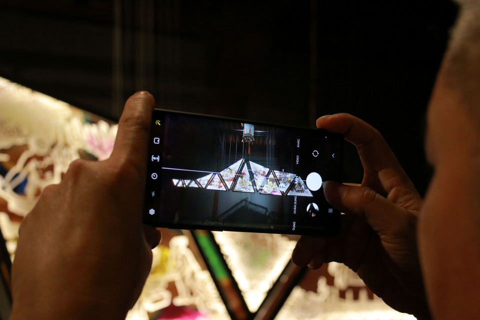 Bên phải tác phẩm là những hình ảnh về nghề rèn, họa tiết mây, vốn cổ. Bên trái là các nghề xưa như đục đá, nghề mộc, đan lọng, làm đèn lồng... (Ảnh: Minh Anh/Vietnam+)