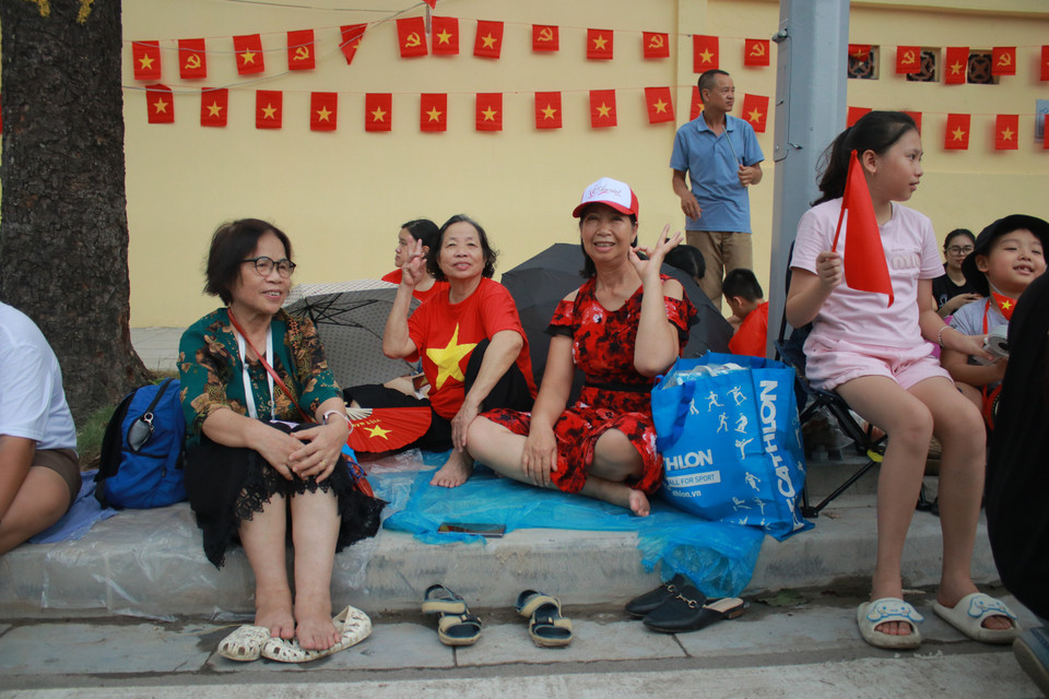 Bà Trương Kim Thoa (80 tuổi) cùng hai người bạn kiêm hàng xóm từ phường Phương Liệt có mặt từ 8 giờ, vào viếng Lăng Bác, đi thăm thú các điểm lận cận. Đến 10 giờ, các bà đã yên vị trên đường Hùng Vương chờ. (Ảnh: Minh Anh/Vietnam+)