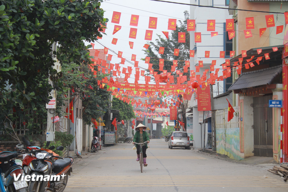 Cờ hoa rực đỏ một góc phố. (Ảnh: Minh Anh/Vietnam+)