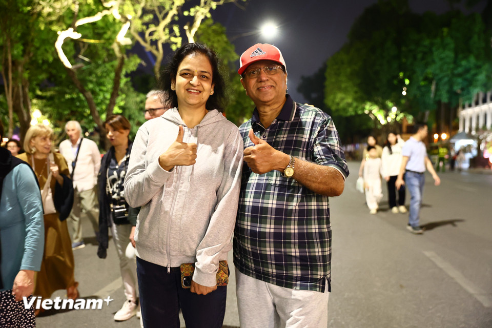 Ông bà Devanathan và Padmaja Gopi (từ Canada) chia sẻ từng có 36 năm quản lý một nhà hàng Ấn Độ tại Hà Nội nên rất quen với phong tục, tập quán và ẩm thực Tết Việt. "Hôm nay chúng tôi sẽ ở đây chờ xem pháo hoa vì rất thích không khí ăn mừng rộn ràng của người dân địa phương, giống như chính chúng tôi cũng là người địa phương vậy." (Ảnh: Minh Anh/Vietnam+)