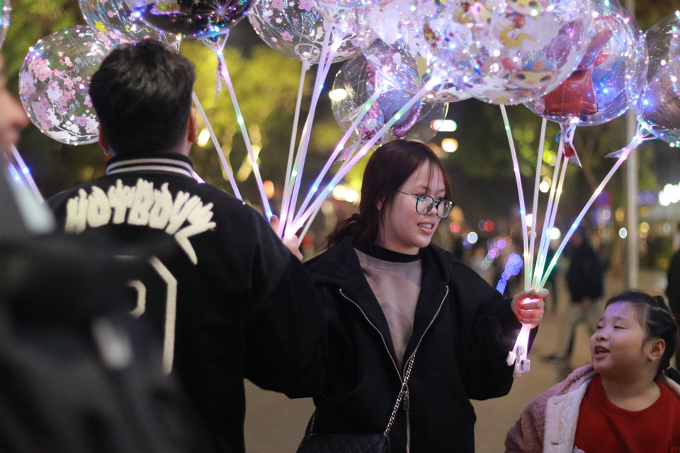 Các bạn trẻ mua nhiều món trang trí để chụp hình vào khoảnh khắc Giao thừa. (Ảnh: Minh Anh/Vietnam+)