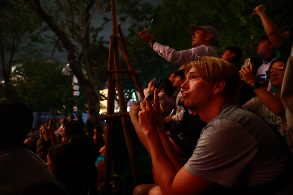 Một du khách kết hợp cả hai cách, ghi hình bằng điện thoại và "ghi hình" bằng các giác quan. (Ảnh: Minh Anh/Vietnam+)