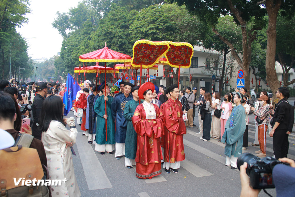 Đoàn diễu hành phong cách thời nhà Nguyễn, cô dâu diện nhật bình, chú rể mặc áo ngũ thân, được che lọng. (Ảnh: Minh Anh/Vietnam+)