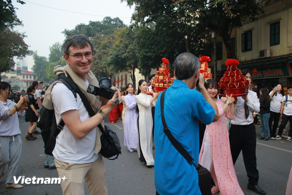 Một khách nước ngoài ghé Hồ Gươm đúng dịp đặc biệt. Giống như nhiều du khách khác, anh lập tức bị chú ý và tưởng rằng đây là đám cưới thật. (Ảnh: Minh Anh/Vietnam+)