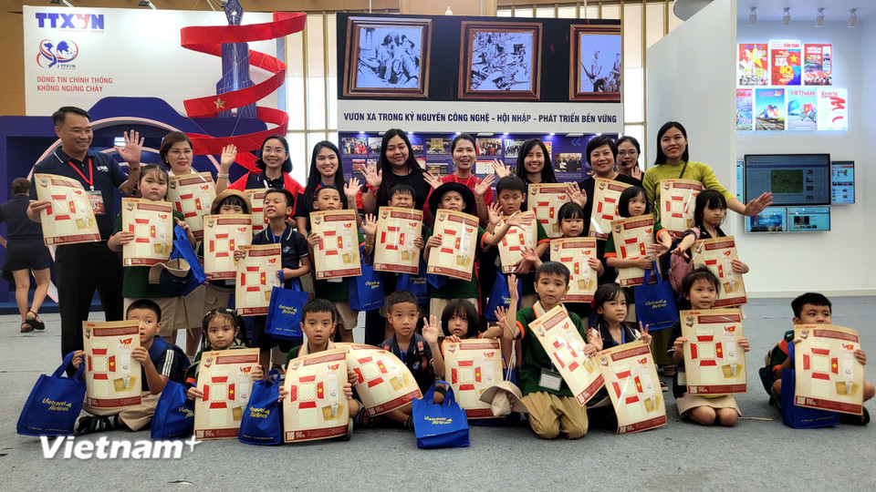 Các em học sinh tham quan và được phát tặng mô hình cắt giấy kỷ niệm 80 năm Quốc khánh. (Ảnh: Minh Anh/Vietnam+)