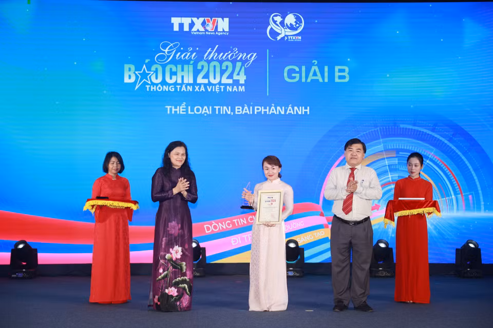 Nhà báo Nguyễn Mai Anh (đại diện nhóm tác giả, gồm: Võ Mạnh Hùng, Nguyễn Mai Anh, Võ Hoàng Long, Báo Điện tử VietnamPlus) nhận giải cho tác phẩm "Quốc hội chia sẻ, đồng hành cùng Chính phủ đưa quyết sách đi vào cuộc sống." (Ảnh: Hoài Nam/Vietnam+)
