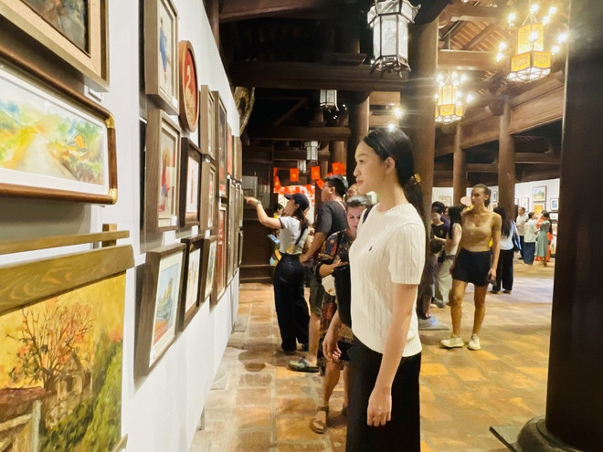 Nhiều khán giả trẻ thích thú xem tranh trưng bày tại triển lãm. (Ảnh: Tuyết Mai/TTXVN) txvn-trien-lam-tranh-nuoc-non-ngan-dam2.jpg
