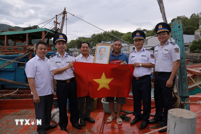 Tổ tuyên truyền của Bộ Tư lệnh Vùng Cảnh sát biển 4 cùng lãnh đạo địa phương xuống tận từng tàu cá đang neo đậu tại cảng trên địa bàn xã Hòn Tre, An Giang để tuyên truyền pháp luật, trao quà cho bà con ngư dân. (Ảnh: TTXVN phát) ttxvn-to-chuc-tuyen-tuyen-pho-bien-phap-luat-cho-ngu-dan-an-giang.jpg