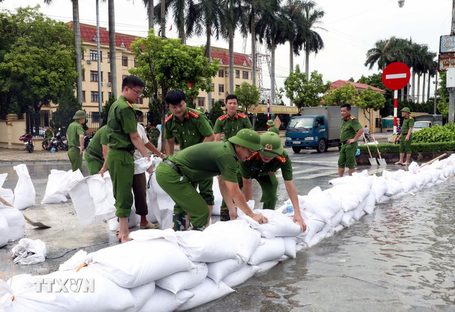 Lực lượng công an phòng quản lý hành chính công an tỉnh Ninh Bình giúp dân đắp đê tạm chống lũ tại sông Đáy. (Ảnh: Nguyễn Chinh/TTXVN) ttxvn-luc-luong-vu-trang-ninh-binh-giup-dan-phong-chong-lu-lut.jpg