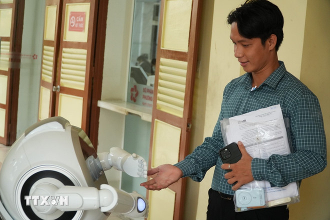 Mensen interacteren met robots in het Saigon Ward Public Administration Service Center. (Foto: Huu Duyen/VNA) ttxvn-nen-hanh-chinh-hien-dai-o-sieu-do-thi-thanh-pho-ho-chi-minh4.jpg