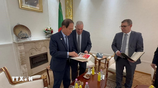 Mr. Vo Hong Nam presenterer en bok om Dien Bien Phu - på arabisk - til den algeriske ministeren for veteraner og krigsveteraner Abdelmalek Tacherift. (Foto: Nguyen An/VNA) ttxvn-viet-nam-algeria-tang-cuong-giao-luu-nhan-dan-phat-huy-gia-tri-doan-ket-cach-mang4.jpg