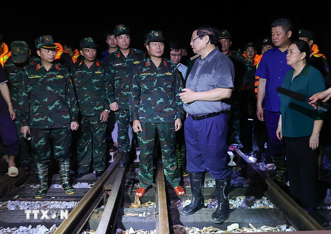 Thủ tướng Phạm Minh Chính kiểm tra tuyến đường sắt bị sạt lở do ảnh hưởng của lũ trên sông Cầu. (Ảnh: Dương Giang/TTXVN) ttxvn-thu-tuong-kiem-tra-chi-dao-ung-pho-lu-tai-khu-vuc-ngoai-thanh-ha-noi8.jpg