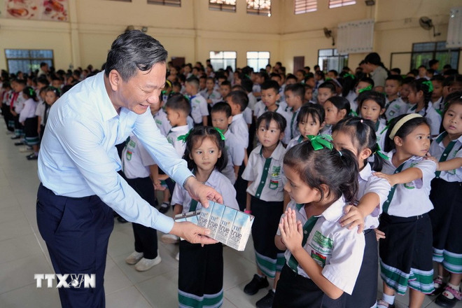 Đại sứ Nguyễn Minh Tâm tặng sữa cho các học sinh Trường song ngữ Lào - Việt Nam Nguyễn Du. (Ảnh: Đỗ Bá Thành/TTXVN) ttxvn-trao-yeu-thuong-ket-noi-tinh-than-viet-lao2-resize.jpg