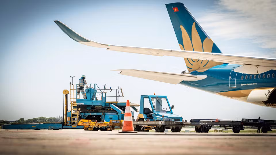 Hơi nóng phả ra từ động cơ máy bay khiến công việc của nhân viên dưới sân đỗ thêm phần vất vả, đẫm mồ hôi. (Ảnh: Phan Công/Vietnam+)