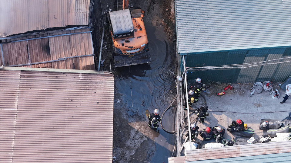 Nhận được tin báo, lực lượng Cảnh sát Phòng cháy chữa cháy và cứu nạn cứu hộ được điều động đến hiện trường. Đến 13 giờ 15, đám cháy vẫn bùng lớn. Dãy nhà xưởng nằm sâu trong ngõ, nguồn nước hạn chế nên việc cứu hoả gặp nhiều khó khăn. (Ảnh: Hoài Nam/Vietnam+)