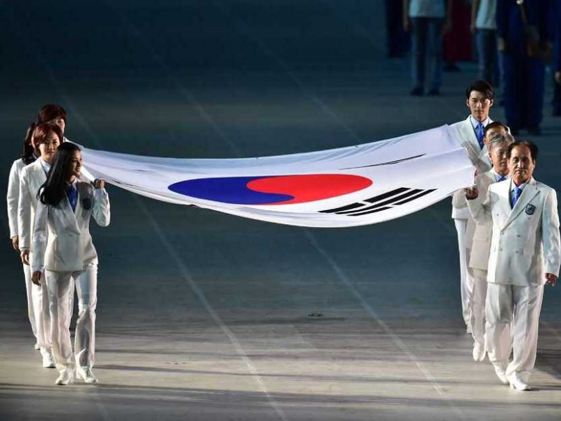 Đoàn chủ nhà Hàn Quốc với quốc kỳ được cầm bởi tám vận động viên kỳ cựu. (Ảnh: AFP)