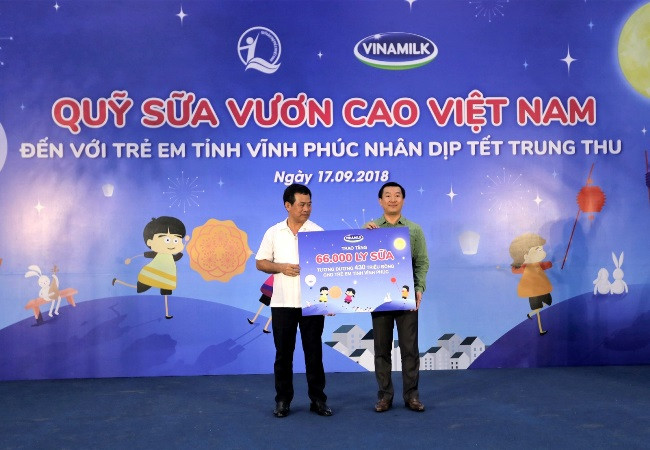  Ông Đỗ Thanh Tuấn - Giám đốc Đối ngoại Vinamilk trao bảng tượng trưng 66.000 ly sữa cho đại diện tỉnh Vĩnh Phúc. ( Ảnh: CTV)