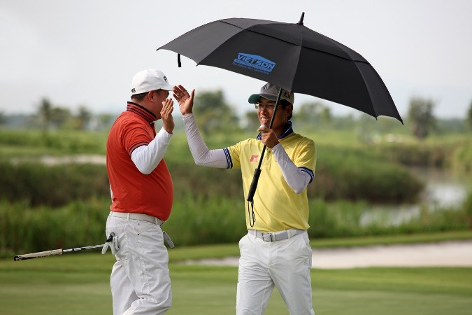 Gôn thủ Hoàng Quân chúc mừng Gôn thủ Lê Thanh Minh sau thực hiện thành công cú putt để ghi một điểm birdie. 