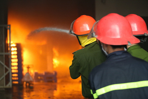 Các lực lượng đang cố gắng hết sức để dập tắt ngọn lửa. (Ảnh: Minh Chiến/Vietnam+)