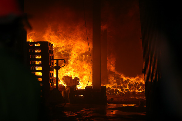 Ngọn lửa bùng cháy dữ dội ở hai kho hàng đầu tiên. (Ảnh: Minh Chiến/Vietnam+) 
