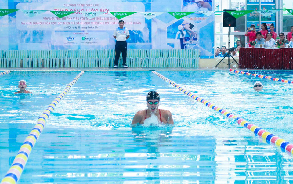 Huấn luyện viên Đặng Anh Tuấn (trên bờ) giám sát cuộc bơi biểu diễn của Ánh Viên. (Ảnh: Hiếu Lương/Vietnam+)