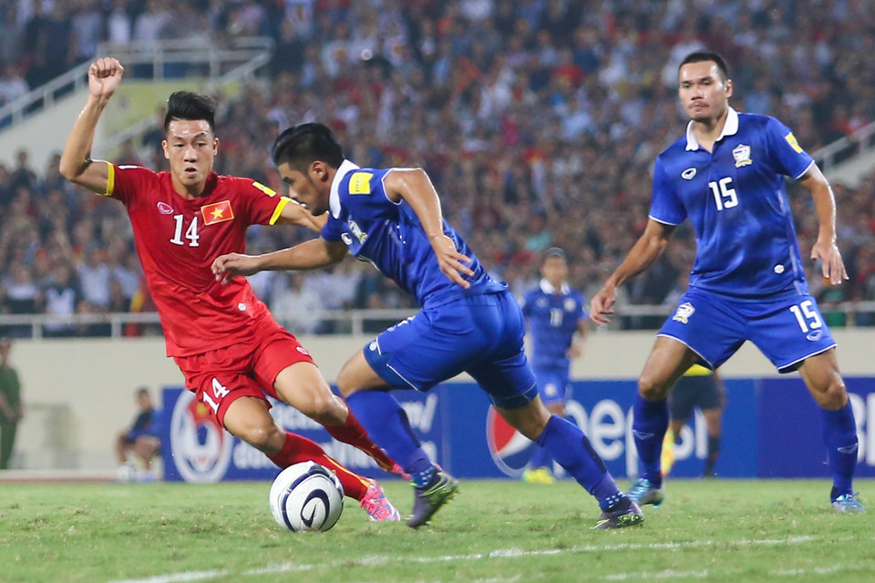 Huy Hùng (áo đỏ) tỏ ra lép vế khi hàng tiền vệ Việt Nam chỉ có ba người, kém quân số so với bốn người của đối thủ. (Ảnh: Minh Chiến/Vietnam+)