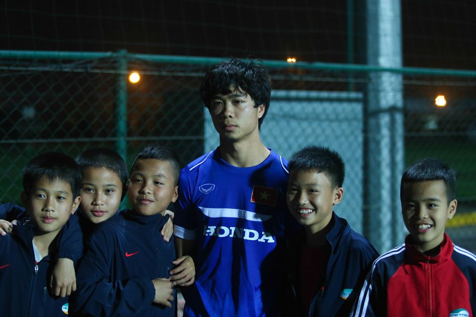 Như thường lệ, anh bị người hâm mộ quây kín sau buổi tập. Trong ảnh, Công Phượng chụp ảnh cùng các tài năng nhí của lò đào tạo Viettel. (Ảnh: Minh Chiến/Vietnam+)