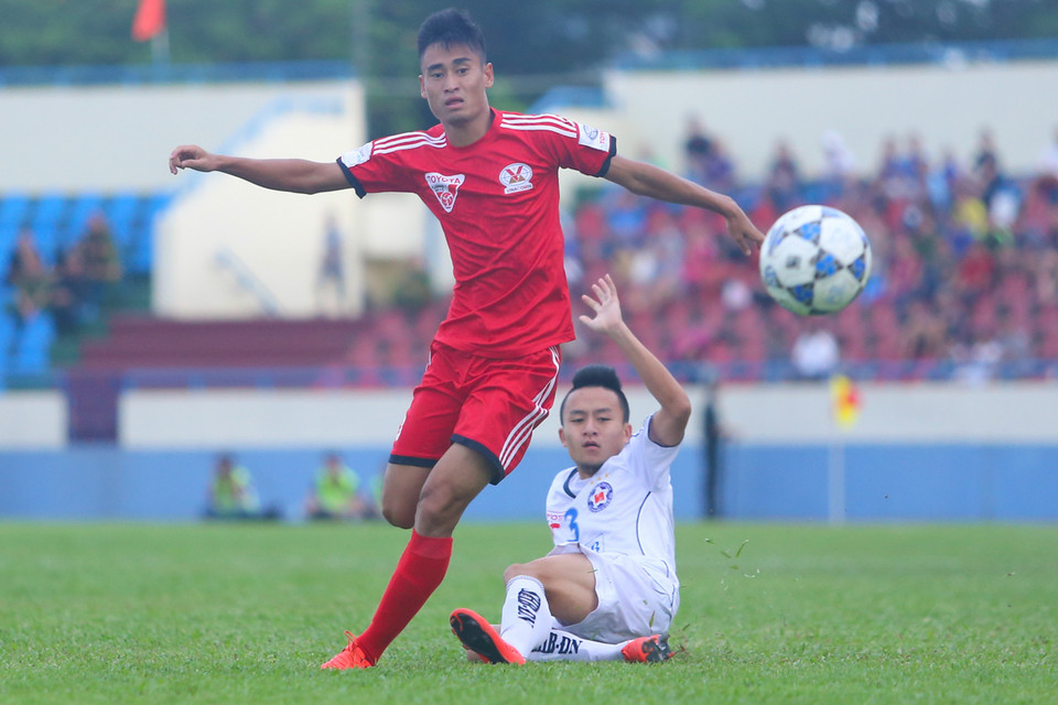 Vũ Minh Tuấn (áo đỏ) trong tình huống tranh chấp với Võ Huy Toàn ở cánh trái. Cả hai đều là những tuyển thủ quốc gia quan trọng của huấn luyện viên Toshiya Miura. (Ảnh: Minh Chiến/Vietnam+)
