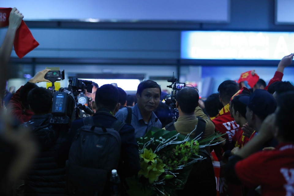 Trưởng đoàn Mai Đức Chung vất vả thoát khỏi vòng vây cổ động viên. (Ảnh: Minh Chiến/Vietnam+)