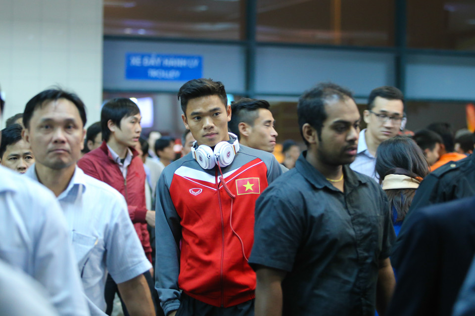 Thủ thành Trần Nguyên Mạnh và các đồng đội giản dị xen lẫn giữa dòng khách đang lấy hành lý. (Ảnh: Minh Chiến/Vietnam+)