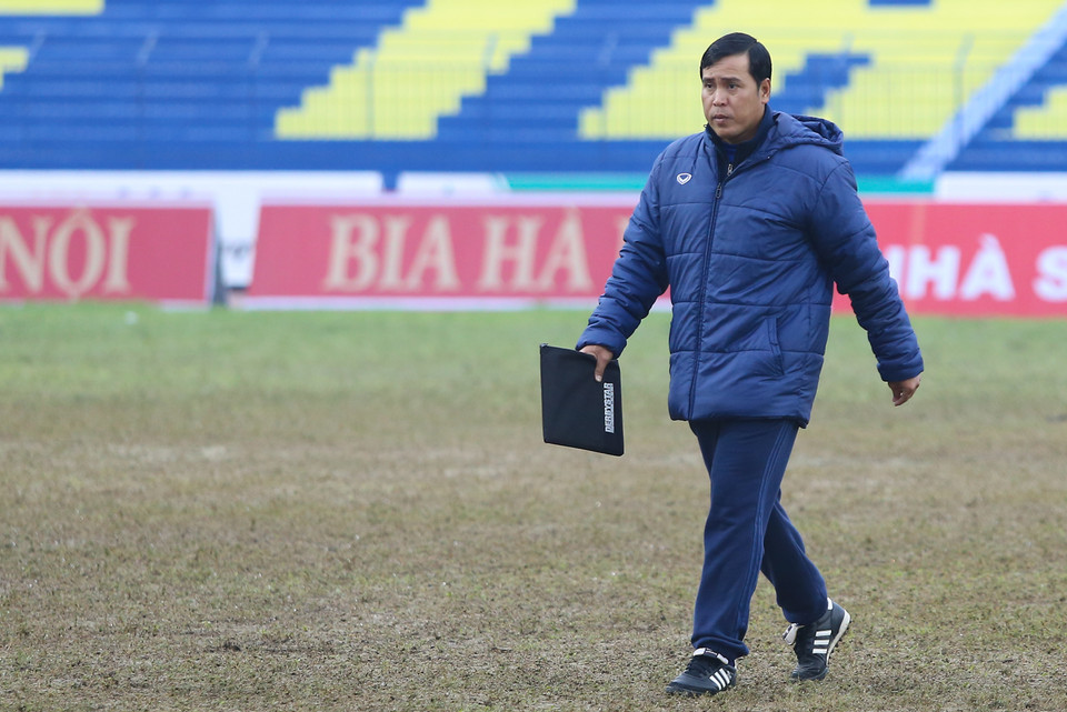 Huấn luyện viên Nguyễn Thanh Sơn của Becamex Bình Dương bước đi trên mặt sân lầy lội, gồ ghề như ruộng cày ở Thanh Hóa. (Ảnh: Minh Chiến/Vietnam+)