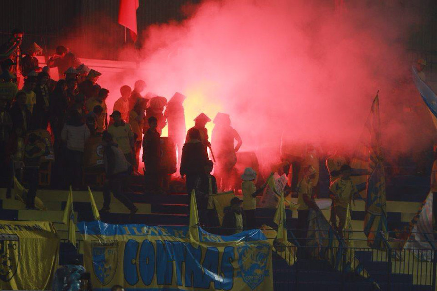 Cổ động viên Hà Nội T&amp;T đốt pháo liên tục ở cuối hiệp hai. Bộ phận an ninh nhiều lần can thiệp nhưng không xử lý được triệt để. (Ảnh: Đỗ Đen/Vietnam+)