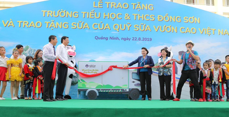 Chủ tịch Quốc hội Nguyễn Thị Kim Ngân cùng các đại biểu và Đại sứ chương trình - Nghệ sĩ Xuân Bắc thực hiện nghi thức mở xe sữa và trao tặng sữa của chương trình Quỹ sữa Vươn cao Việt Nam cho các em học sinh. (Ảnh: CTV)