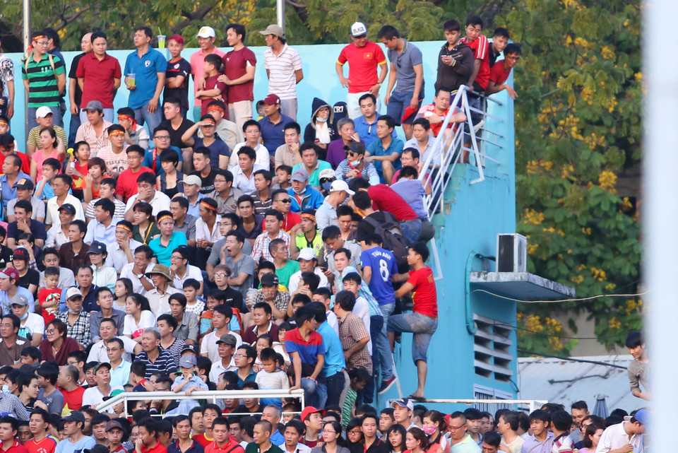Nhiều cổ động viên đã phải trèo tường để tìm cách lên khán đài. (Ảnh: Minh Chiến/Vietnam+)