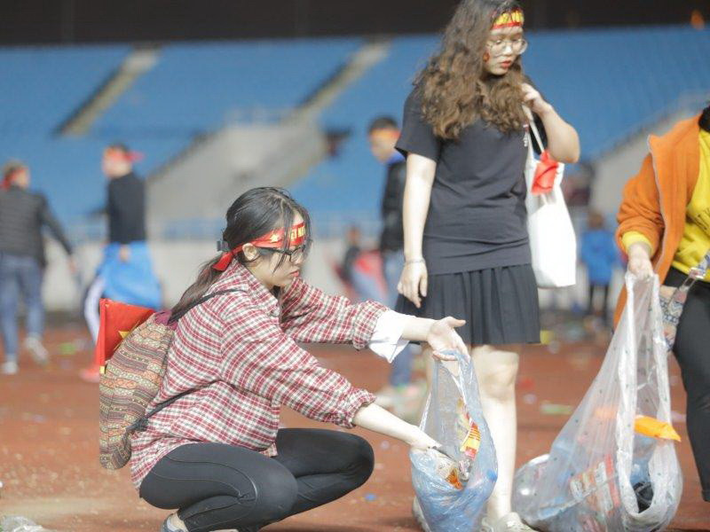 Dưới cơn mưa phùn, hàng trăm bạn trẻ vẫn nán lại nhặt rác trong khi nhiều người đã ra về. (Ảnh: Tá Hiển)