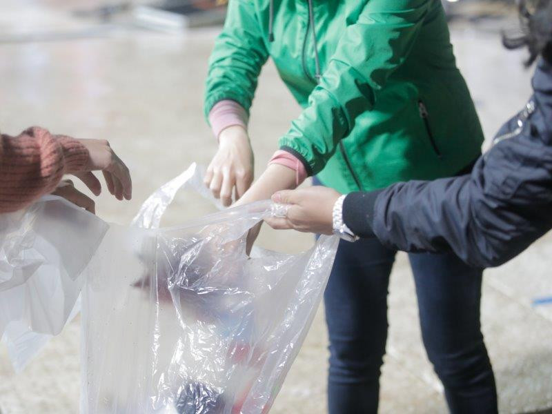 Các bạn chuyền tay nhau những túi bóng để có thể lượm rác và thu gom dễ dàng hơn. (Ảnh: Tá Hiển)