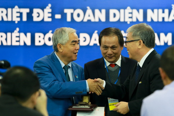 Quyền Chủ tịch Lê Hùng Dũng nhận quà lưu niệm từ đại diện AFC. (Ảnh: Minh Chiến/Vietnam+)