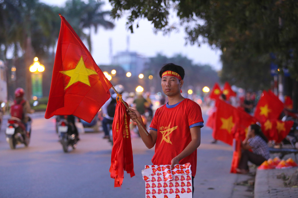 Ngay từ hơn 17 giờ, người hâm mộ đã đổ về Mỹ Đình. Những người bán hàng rong đứng ở đoạn đầu đường Phạm Hùng rẽ vào khu liên hợp Mỹ Đình dài hơn 2km. (Ảnh: Minh Chiến/Vietnam+)