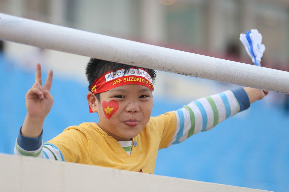 Một fan nhí theo cha cổ vũ đội tuyển. (Ảnh: Minh Chiến/Vietnam+)