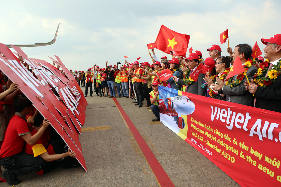 Lãnh đạo của VJ chào đón những vị khách đầu tiên của chuyến bay trở về từ Pháp. (Ảnh: Huy Hùng/TTXVN)
