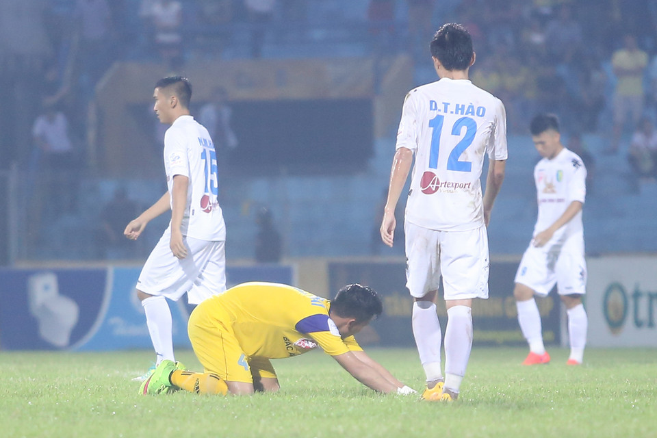 Ngọc Hải (áo vàng) gục xuống sân sau trận thua. Đây là lần đầu tiên sau 7 năm qua, Sông Lam Nghệ An bại trận trước Hà Nội T&amp;T. (Ảnh: Minh Chiến/Vietnam+)