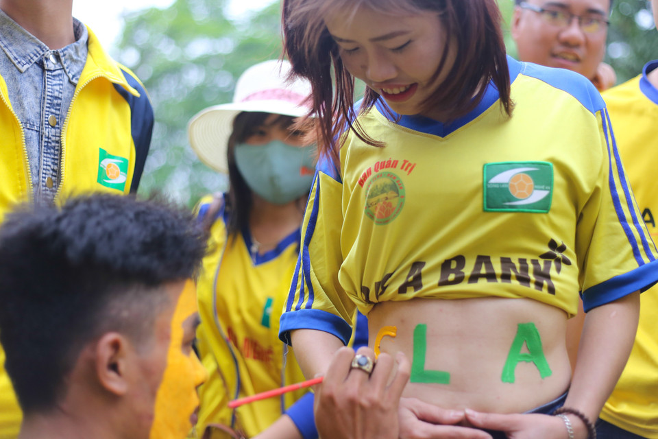 Một “fan” nữ vẽ lên bụng để cổ vũ đội bóng quê hương. (Ảnh: Minh Chiến/Vietnam+)