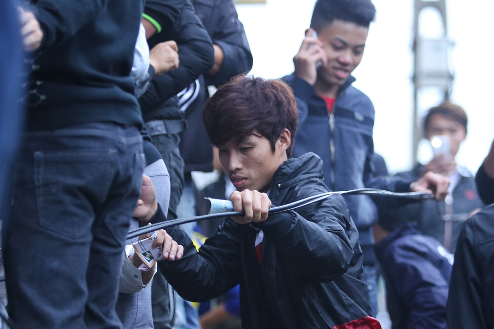 Một cổ động viên đu theo dây diện ở khu bán vé phía sau khán đài B sân Vinh. Anh bất chấp nguy hiểm để có tấm vé xem Công Phượng và đồng đội thi đấu. (Ảnh: Minh Chiến/Vietnam+)