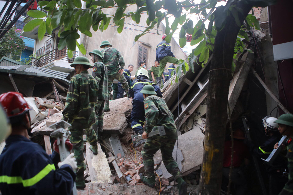 Công tác cứu hộ gặp nhiều khó khăn vì mái nhà lớn sập xuống, không gian cứu hộ nhỏ hẹp. (Ảnh: Minh Sơn/Vietnam+)