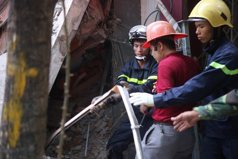 Để đưa được một thanh sắt ra ngoài lúc này, đội cứu hộ cũng phải rất vất vả. (Ảnh: Minh Sơn/Vietnam+)