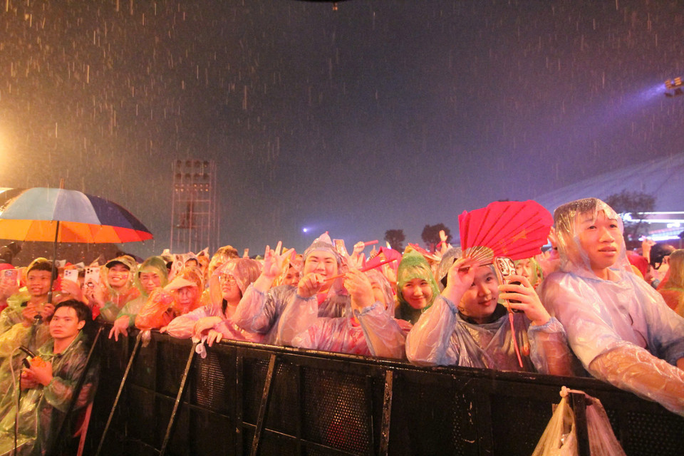 Dù trời mưa lớn và đường ngập nhiều nơi nhưng hàng vạn khán giả vẫn có mặt tại địa điểm tổ chức sự kiện, đội mưa thưởng thức đêm nhạc. (Ảnh: CTV/Vietnam+)