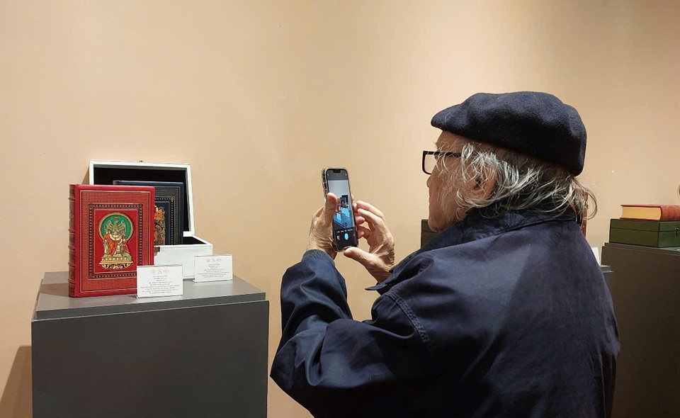 Người yêu sách mê mẩn ngắm nhìn và chụp hình các ấn phẩm hiếm có. (Ảnh: Minh Thu/Vietnam+)