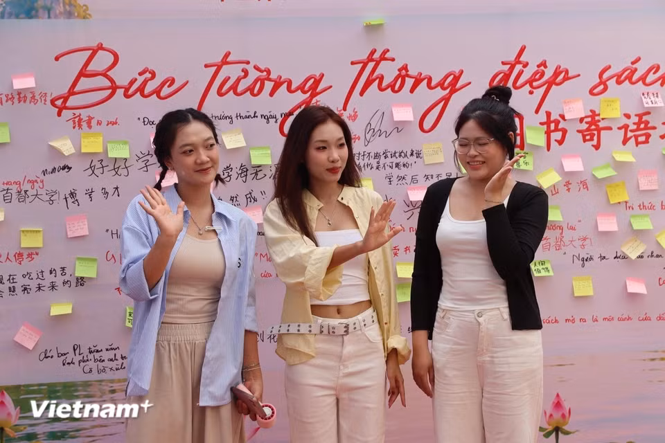 Bên bức tường thông điệp, nhiều sinh viên lưu lại khoảnh khắc tham gia ngày hội như một kỷ niệm về trải nghiệm văn hóa trong khuôn viên trường. (Ảnh: Minh Vũ/Vietnam+)