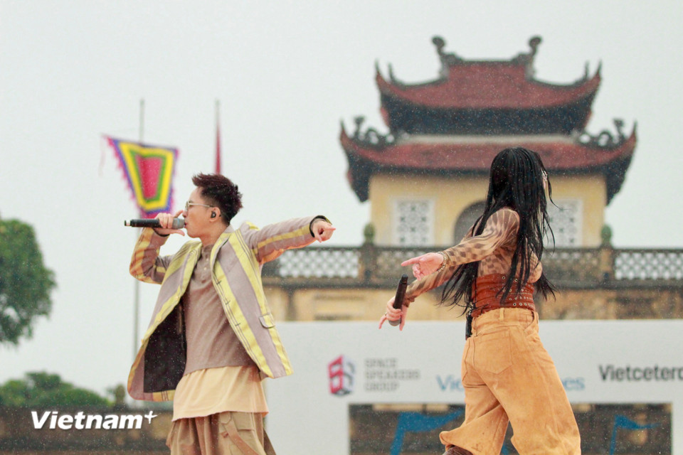 Khi mưa nặng hạt hơn, 2 ca sỹ Tuimi và Rhymastic không che ô, lựa chọn hòa mình cùng khán giả, biến khoảnh khắc ướt mưa thành kỷ niệm khó quên. (Ảnh: PV/Vietnam+)